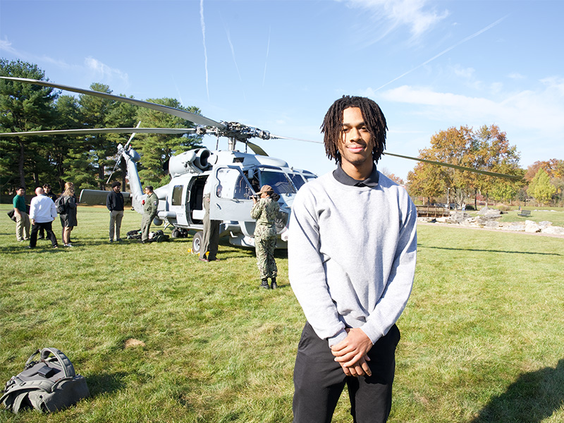 MHS Senior Josh Gibb standing outside a Navy helicopter