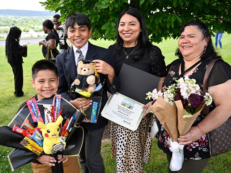 A member of the Class of 2028 stands with their family after the Eighth Grade Promotion Ceremony.